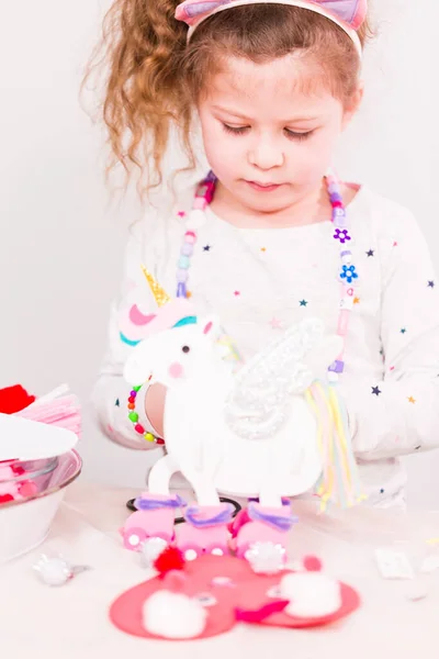 Mała Dziewczyna Podejmowania Rzeźby Jednorożca Spośród Arkuszy Pianki Multicolor — Zdjęcie stockowe