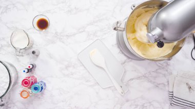 Tereyağlı krema yapmak için mutfak mikserinin malzemelerini karıştırıyorum..