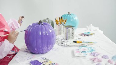 Adım adım. Süslü deniz kızı Cadılar Bayramı balkabağı yaratmak için akrilik boyalı balkabağı boyamak.