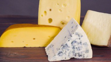 Kaba ahşap arka planda büyük gurme peynirleri..