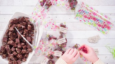 Düz yatıyordu. Adım adım. Ev yapımı macadamia şekerlemesi küçük hediye paketlerine konuyor..