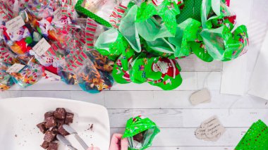 Düz yatıyordu. Adım adım. Ev yapımı macadamia şekerlemesi küçük hediye paketlerine konuyor..