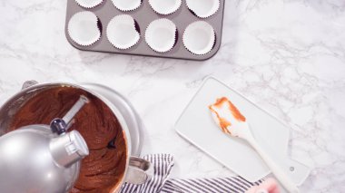 Düz yatıyordu. Adım adım. Kırmızı kadife kekler pişirmek için mutfak mikserinin malzemelerini karıştırıyorum..