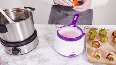 Adım adım. Erimiş çikolataya organik çilek batırmak..