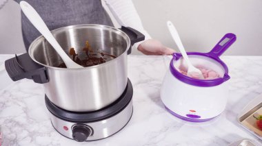 Adım adım. Çikolata parçacıkları eriyen kaplarda eriyor..