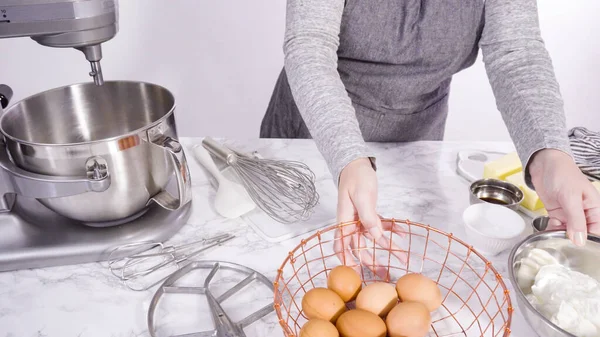 Step by step. Mixing ingredients in standing kitchen mixer to bake funfetti cake.