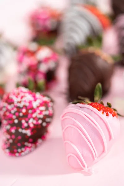 ピンクの背景に様々なチョコレートがイチゴを浸した — ストック写真