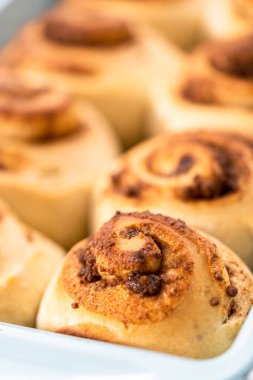 Mavi bir tavada taze pişmiş tarçınlı rulo..