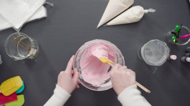 Adım adım. Düz yatıyordu. Şekerli kurabiyeleri süslemek için kraliyet kremasına gıda boyası karıştırmak..