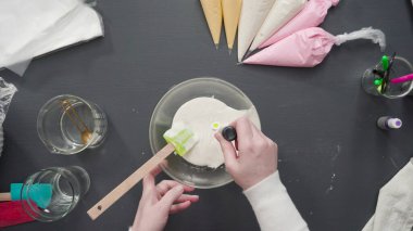 Adım adım. Düz yatıyordu. Şekerli kurabiyeleri süslemek için kraliyet kremasına gıda boyası karıştırmak..