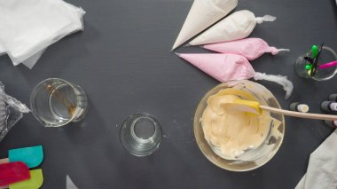 Adım adım. Düz yatıyordu. Şekerli kurabiyeleri süslemek için kraliyet kremasına gıda boyası karıştırmak..