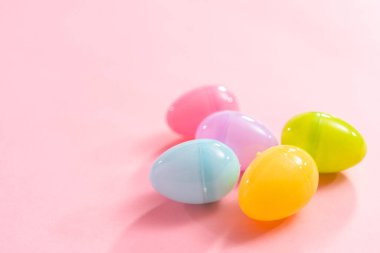Pembe arka planda plastik Paskalya yumurtaları.