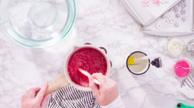 Düz yatıyordu. Adım adım. Ev yapımı lolipoplar yapmak için gıda tadını karamelize şekere karıştırmak.