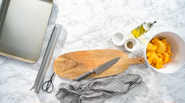 Flat lay. Roasting butternut squash with salt and pepper in olive oil.