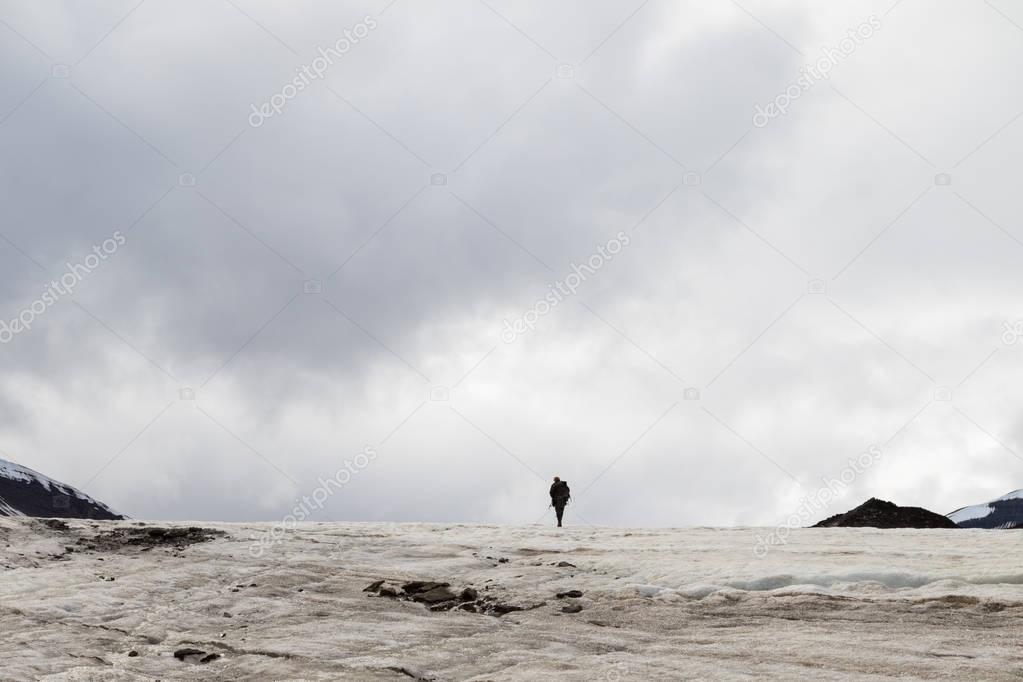 Man walking away in the distance on a glacier