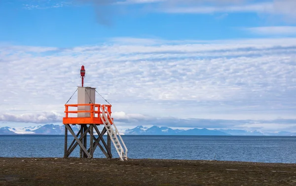 Toren op het strand naast de luchthaven in Svalbard, de Oceaan en de bergen in de achtergrond — Stockfoto