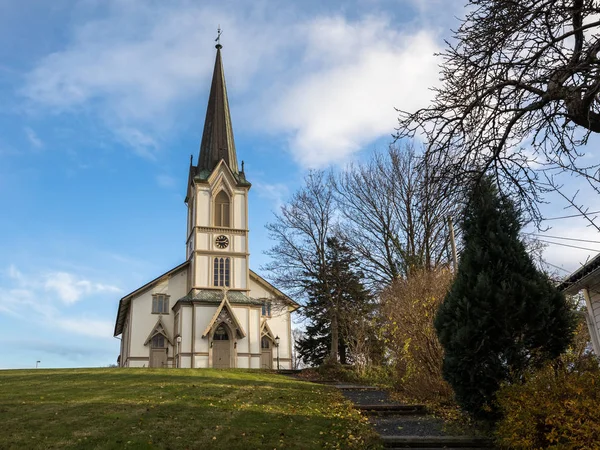 Lillesand, Noruega - 10 de noviembre de 2017: La iglesia de Lillesand. Vista frontal. Cielo azul, nubes, hierba verde y escalera . — Foto de Stock