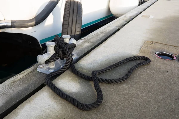 Barco blanco atado al muelle con una cuerda negra — Foto de Stock