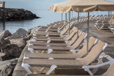 Şezlong ve şemsiye plajda Playa de Puerto Rico Kanarya Adası dalgakıran, satır