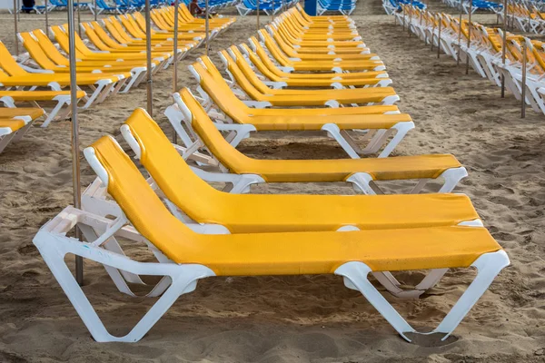 Rader av gula solstolar på stranden Playa de Puerto Rico på Canary ön — Stockfoto