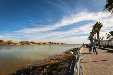 Maspalomas Gran Canaria, İspanya - Aralık 11, 20017: La Charca, kuş gözlem yerinde Maspalomas Dunes tabiatı. Sağ tarafta turist ile Promenade yürüyüş.