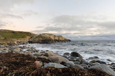 Çakıl kıyı ve Hove, Arendal, Norveç'te Tromoy denizde kayalarla. Raet Milli Parkı. Uzun pozlama.