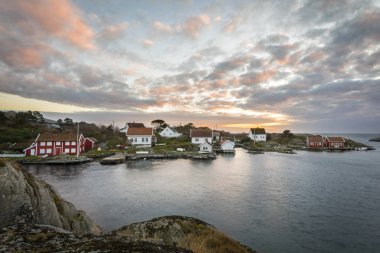 Lillesand, Norveç - 7 Kasım 2017: Ulvoysund, okyanus ve akşam ışık YSTW Ulvoya eski evler.