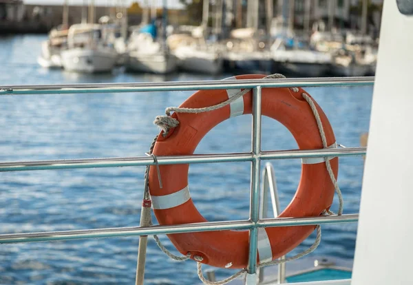 Boya salvavidas en un ferry, veleros fuera de foco en el muelle en el fondo. Puerto de Mogan, Gran Canaria en España — Foto de Stock