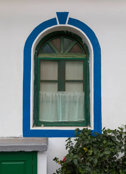 Janela borboleta misturada em um edifício branco com tinta verde e azul, ao ar livre, Puerto de Mogan, Gran Canaria em Espanha — Fotografia de Stock