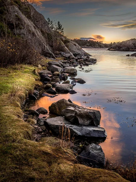 Abendlicht, Meer, Steine und Felsen am Meer, warmes Licht und Sonnenuntergang im Hintergrund. — Stockfoto