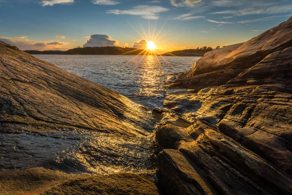 Abendlicht, Meer, Felsen am Meer, warmes Licht und Sonnenstern im Hintergrund. — Stockfoto