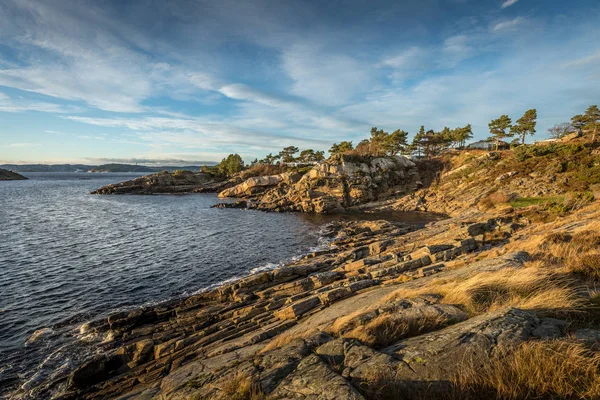 Soleado día de invierno junto al océano, rocas y acantilados junto al mar . — Foto de Stock