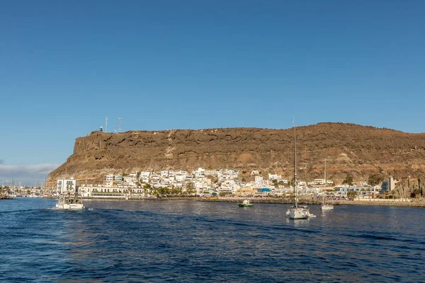 Gran Canaria, Canary Islands in Spain - December 16, 2017: Sailboats, ferry and boats in the ocean in front of the old fishing village Puerto de Mogan — Stock Photo, Image
