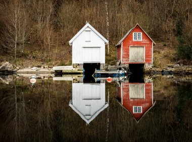 Kolnes Norveç - januray 10, 2018: iki eski ahşap boathouses yansıyan sakin okyanusta. Norveç west coast, Norveç