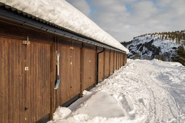 Edificio marrón gigae, nieve en el suelo, montañas y nubes blancas en el cielo azul — Foto de Stock