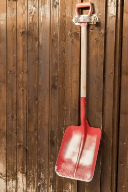 Bir kilit ile güvenli bir kahverengi duvarda asılı kürek kullanılan.