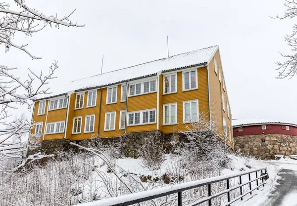 Odderoya en Kristiansand, Noruega - 17 de enero de 2018: Lasarettet, antiguo edificio amarillo de 1804, construido como cuarentena para prevenir la propagación de la enfermedad del cólera. Foto tomada en invierno, nieve en el suelo . — Foto de Stock
