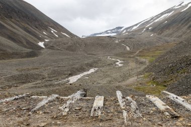 Eski ahşap günlükleri, kullanılan kömür madencilik sektörü, Longyear Vadisi, Svalbard kayalarda buzul buzultaş manzara için. Kutup manzara.