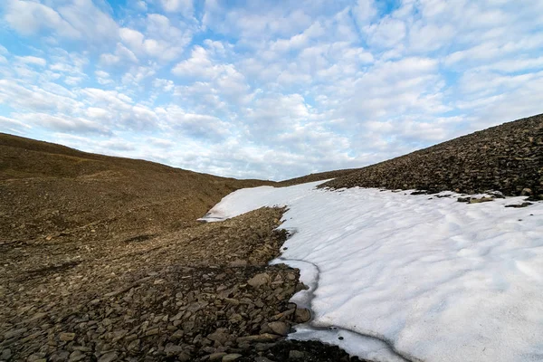 Még néhány hó augusztusban Platafjellet maradt. Svalbard nyáron. Sziklás hegyek, kék ég és fehér felhők felett. Éjfélkor, jelenet világosítja a midnight Sun. — Stock Fotó