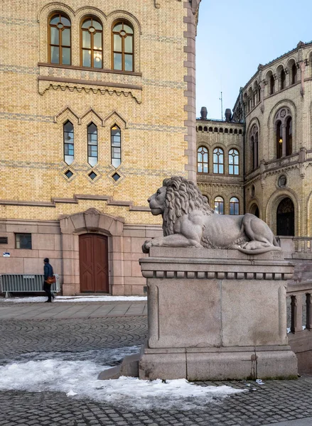 Oslo, norwegen - 16. märz 2018: außenansicht des norwegischen parlaments in oslo, norwegen. die Löwenstatue beobachtet einen einsamen Fußgänger. — Stockfoto