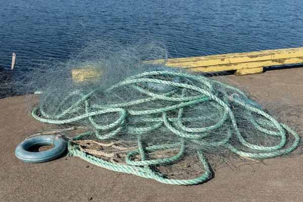 Rede de pesca verde no porto com mar azul no fundo — Fotografia de Stock
