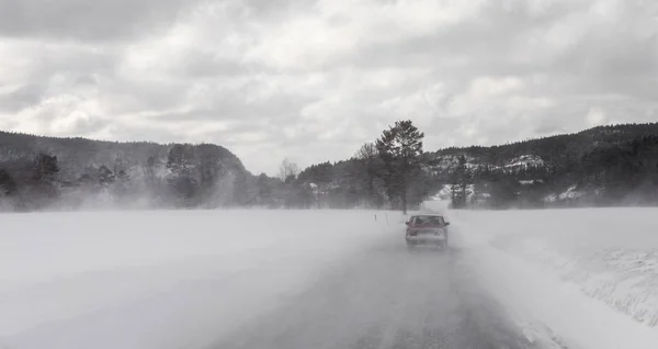Car driving in winter blizzard on snowy road in Norway — Stock Photo, Image