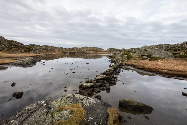 Estanque junto al sendero, en el archipiélago de Rovaer, isla en Haugesund, Noruega. Piedras haciendo un camino a través del agua . —  Fotos de Stock