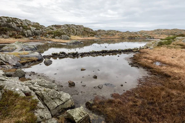 Rovaer 列島、ハウゲスン、ノルウェーの島で、トレイルで池。水の経路を作る石. — ストック写真