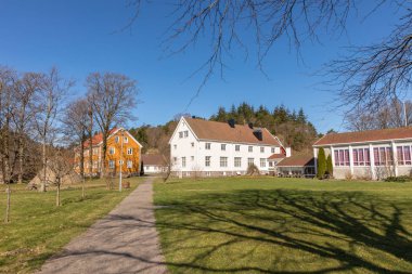 Sogne, Norveç - 21 Nisan 2018: Sogne Gamle Prestegard, ya da eski Sogne papaz. Papaz evine ahşap binalar, Vest-Agder Norveç'te. Mavi gökyüzü, yeşil çim.