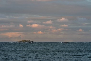 Pembe gökyüzü ve bulutlar adalar Faerder Milli Parkı, Norveç'in ve okyanus üzerinde gündoğumu