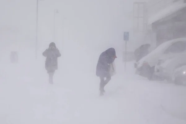 Longyearbyen 'de kar fırtınası. Kar yağışı altındaki insanlar. Soyut bulanık kış havası arkaplanı