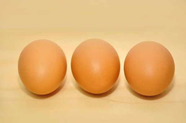Kolme raakaa munaa peräkkäin — kuvapankkivalokuva
