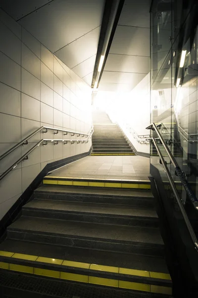 Podzemní chodba se schody vedoucí nahoru světlo. — Stock fotografie