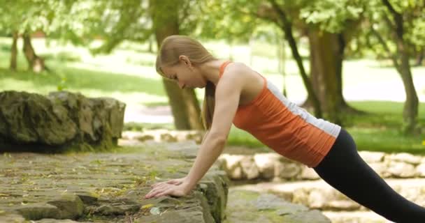 Attraktiv ung flicka övning i parken — Stockvideo
